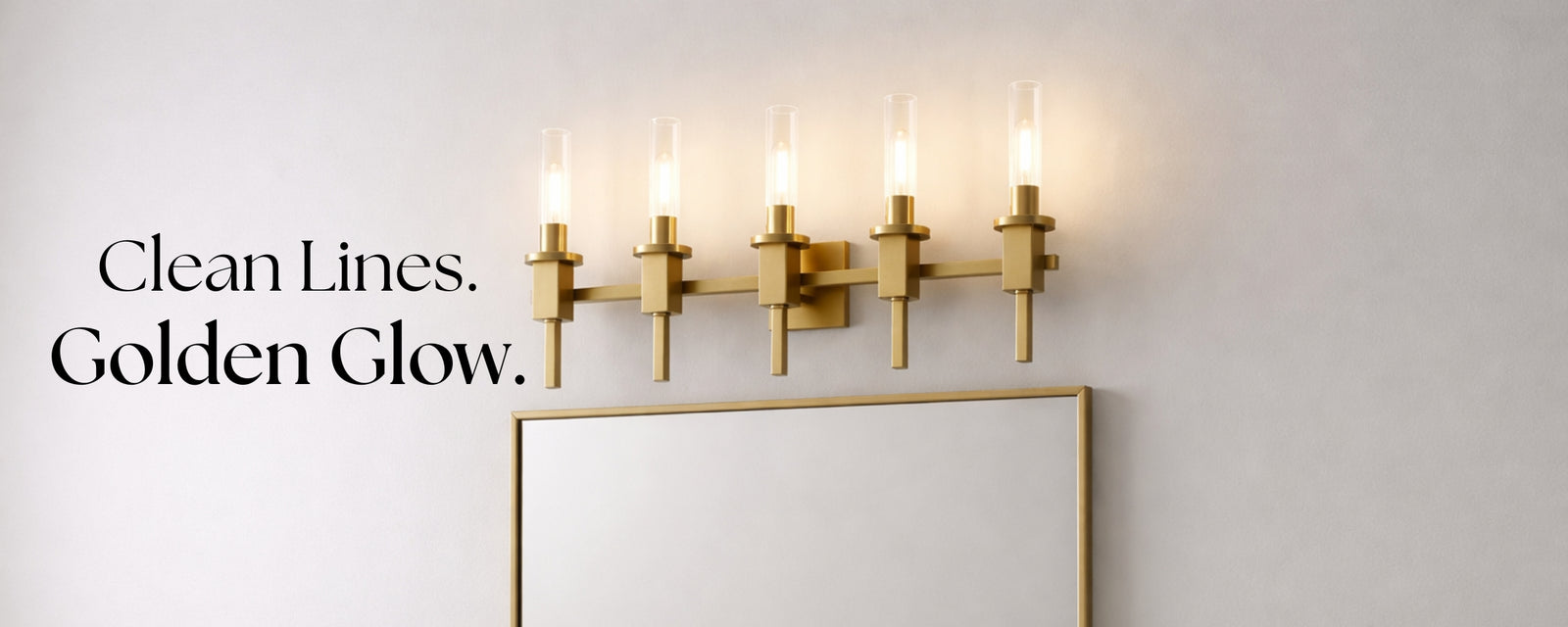Modern gold 5-light vanity light with clear glass shades above a bathroom mirror, creating a clean and elegant glow.